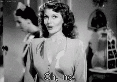 a black and white photo of a woman standing in a room and saying oh , no .