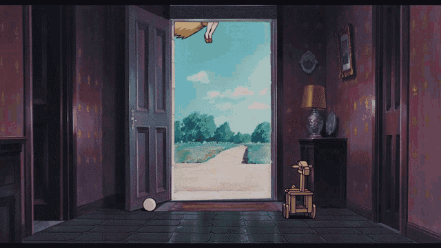 a little girl with a red bow on her head is standing in front of a door holding a broom
