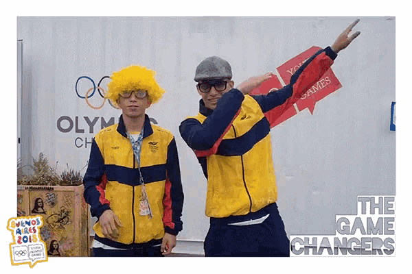 two men are posing for a photo in front of a sign that says the game changers