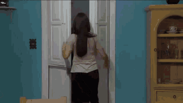 a woman with red hair is standing in a doorway with her mouth open .
