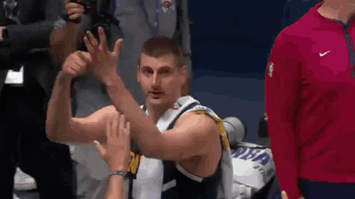 a basketball player is giving a high five to a fan