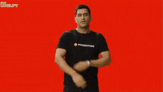 a man wearing a black t-shirt with pokerstars on it is dancing against a red background .