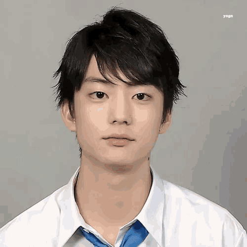 a young man wearing a white shirt and a blue tie .