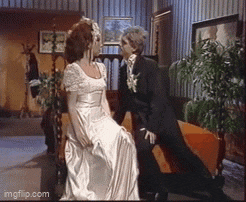 a man in a tuxedo and a woman in a wedding dress are kissing