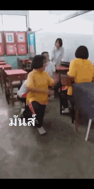 a group of people are dancing in a classroom with chinese writing on the floor .