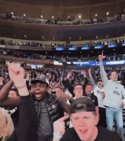 a crowd of people in a stadium with a man wearing a white shirt that says ' chicago bulls ' on it