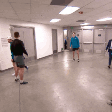 a man in a blue shirt stands in a hallway