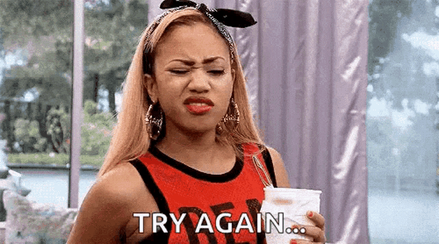 a woman in a red tank top is holding a cup and making a face .
