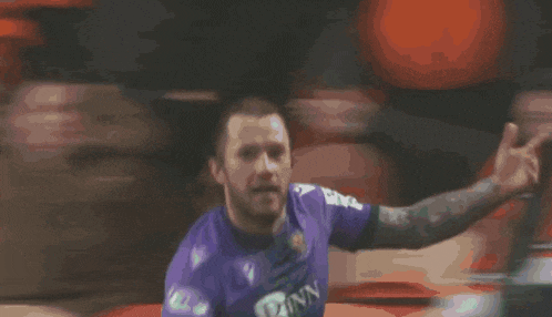 a soccer player in a purple jersey with the number 23 on it