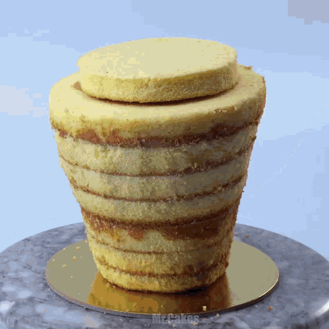 a cake sitting on top of a gold plate that says mrcakes on it