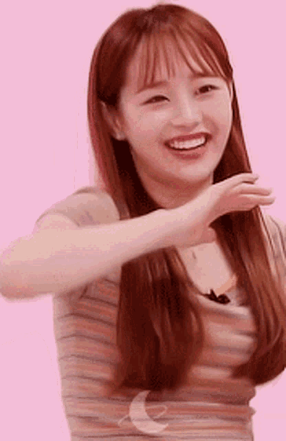 a close up of a woman 's face with a pink background .