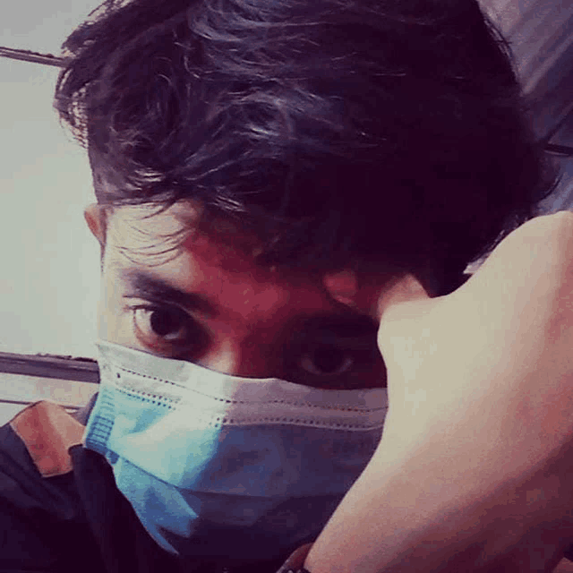 a man wearing a blue face mask covering his face
