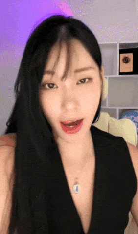 a woman with braces on her teeth is wearing a black dress and necklace .