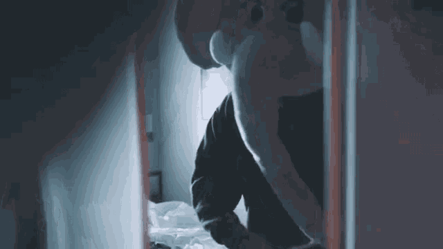 a man is wearing an elephant mask and standing in a dark room .