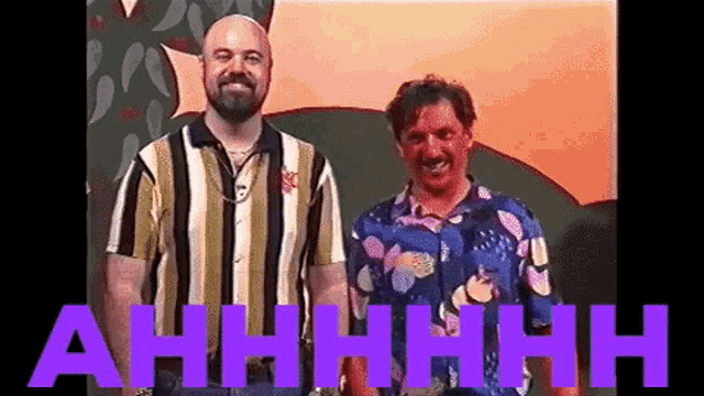 two men are standing next to each other in front of a sign that says ahhhhh .