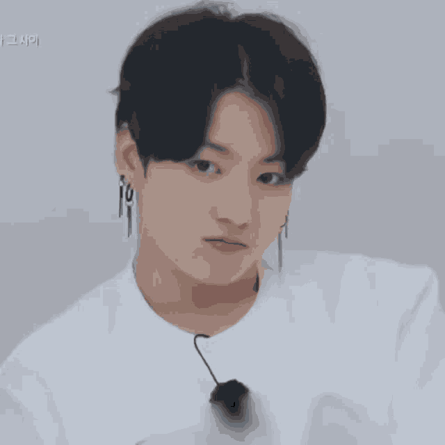 a close up of a person wearing a white shirt with korean writing on it