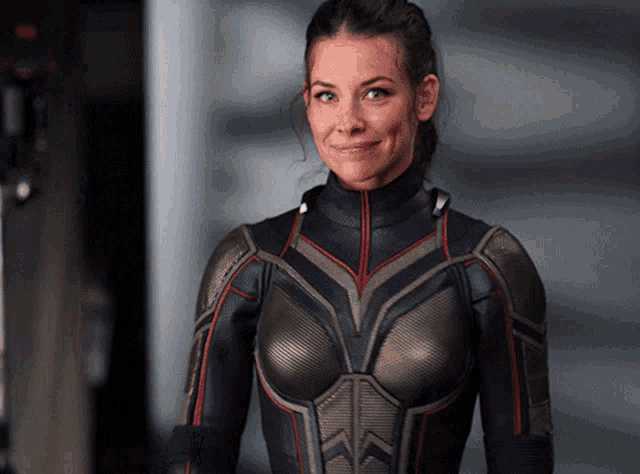 a woman in a superhero suit smiles at the camera