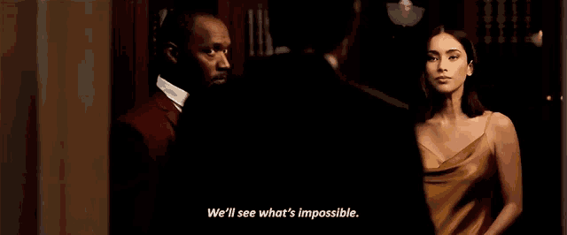 a woman in a yellow dress says we 'll see what 's impossible while standing next to a man in a suit