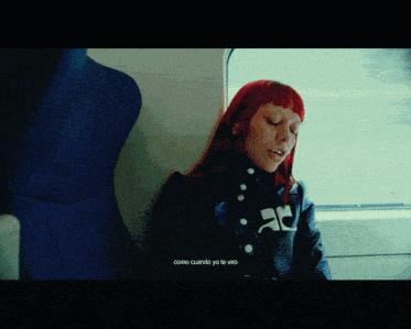 a woman with red hair is leaning against a wall with the words " como cuando yo te veo " on the bottom