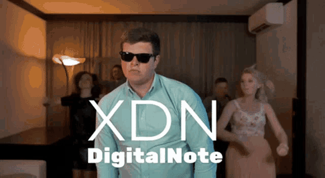 a man in sunglasses is dancing in front of a sign that says xdn