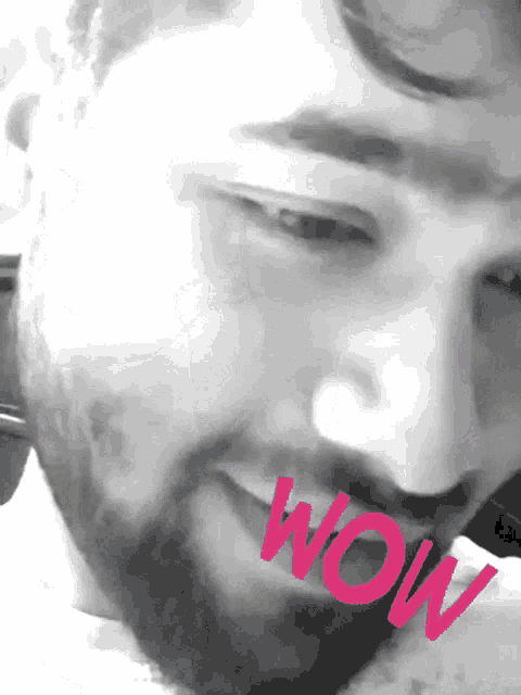 a close up of a man 's face with the word wow written in pink
