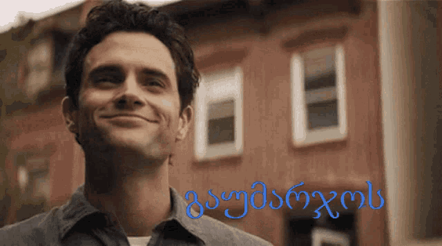 a man is smiling in front of a building with the word georgia on the bottom right