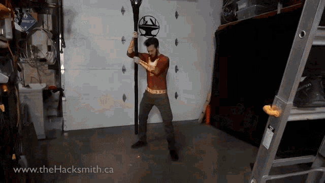 a man in a superhero costume is holding a pole in a garage with the website www.thehacksmith.ca below him