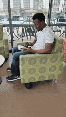 a man sits on a chair reading a book
