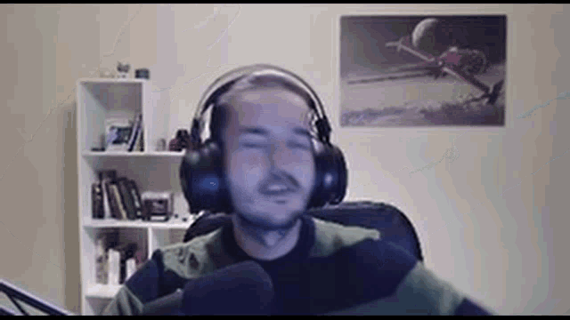 a man is wearing headphones and singing into a microphone .
