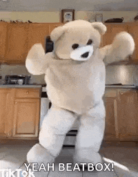 a teddy bear is dancing in a kitchen in a costume .