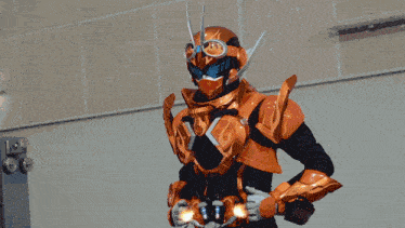 a man in a robot costume with a helmet and goggles is standing in front of a wall