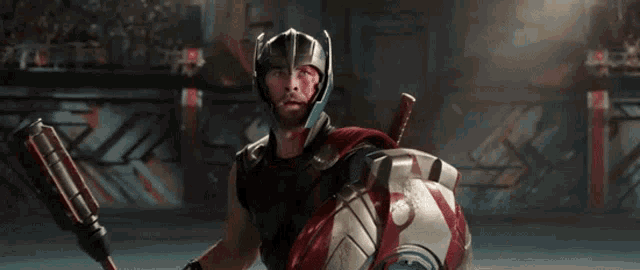 thor is wearing a helmet and holding a shield and a hammer .