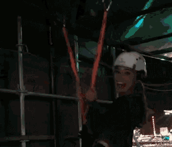 a woman wearing a helmet is smiling while holding a rope