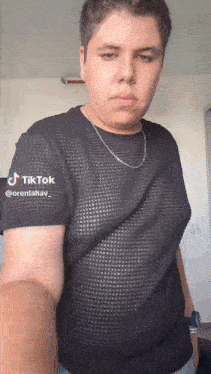 a young man wearing a black shirt and a silver chain has a tiktok account