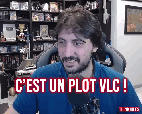 a man sitting in front of a microphone with the words c'est un plot vlc written above him
