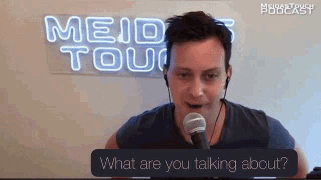 a man is talking into a microphone in front of a neon sign that says ' meid touch podcast '