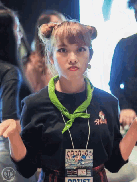 a girl wearing a black shirt with a green bandana around her neck has a tag around her neck that says artist