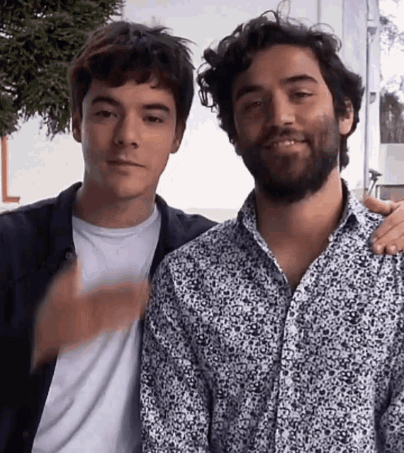 two young men are posing for a picture and one has a beard