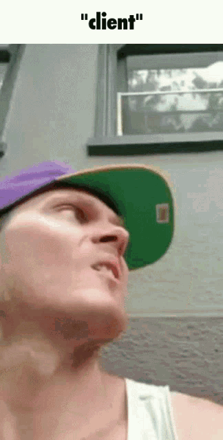 a man wearing a purple hat and a green hat with the words " client " on the bottom