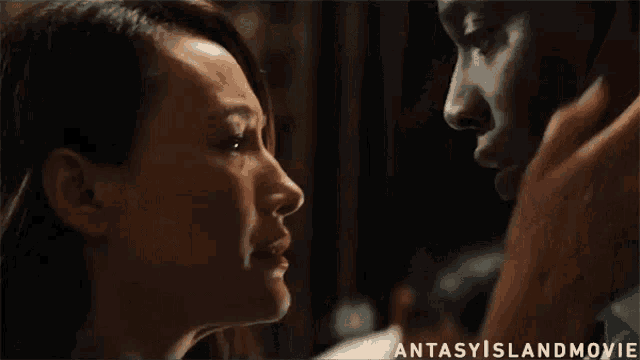 a man and a woman are looking at each other and kissing .