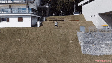 a man is jumping in the air in front of a building that says think jules on the bottom