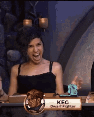 a woman is sitting at a table with a sign that says keg dwarf fighter on it