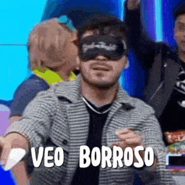 a man wearing a blindfold says veo borroso while a woman whispers into his ear .