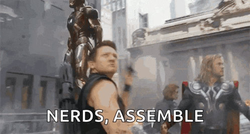 a man holding a statue with the words nerds assemble written on it .