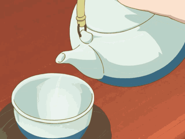 a person pouring green tea into a cup