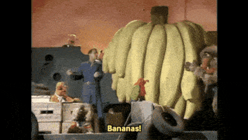 a group of cartoon characters are standing in front of a giant banana that says bananas
