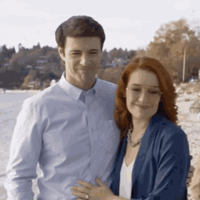 a man and woman posing for a picture on the beach