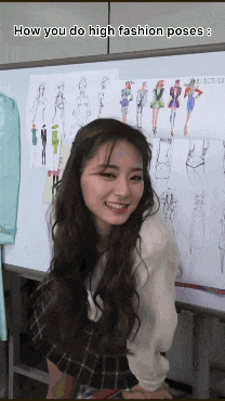 a woman is smiling in front of a white board with drawings of women on it