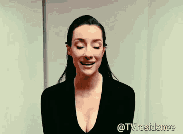 a woman with a plunging neckline is smiling and says @tvresidence