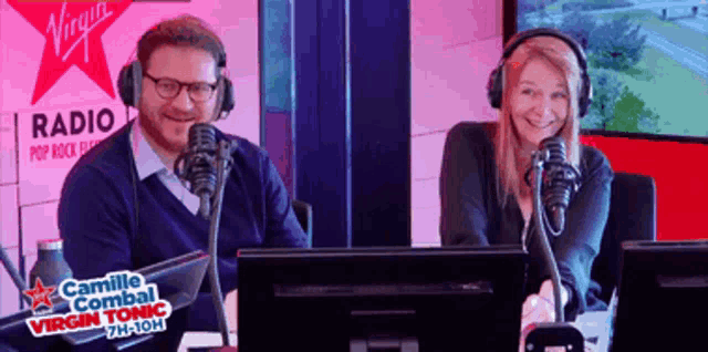 a man and a woman are sitting in front of microphones in front of virgin radio